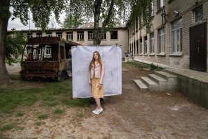 Kateryna*, 16, poses for a portrait at her damaged school outside of Kyiv in Ukraine.