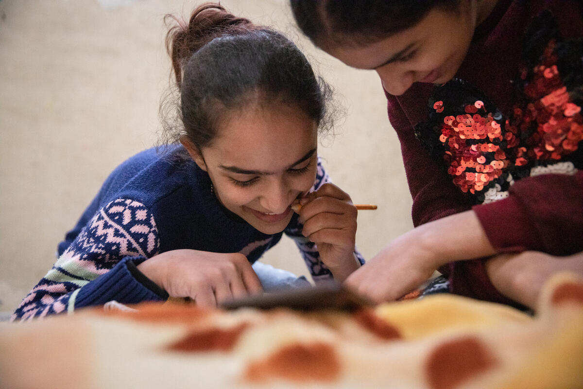 Ghinwa 13 doing an-online lesson with her sister Enaw 14 at their home in a refugee settlement in Beirut Lebanon