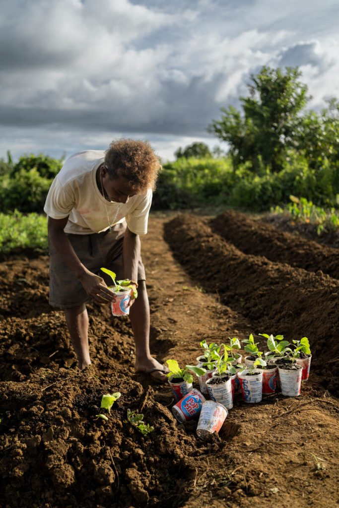 Junior, 16, planting seedlings in a community garden in Malaita Province, the Solomon Islands.