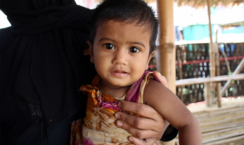 Rohingya refugee Yasmina (8 months) is held by her mother Noor Ayesha (30) at a Save the Children nutrition centre