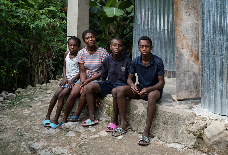 Edlène and her children outside their home in south west Haiti